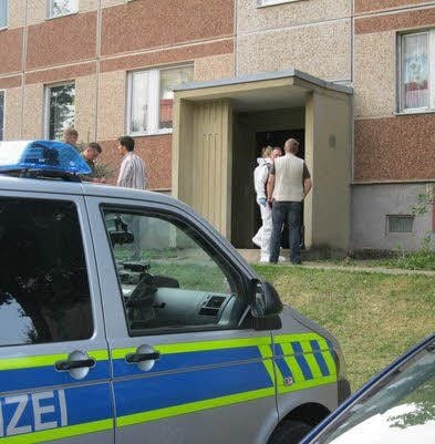 Kripobeamte vor dem Haus, in dem der Mann getötet wurde