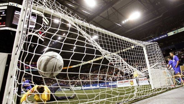 Beim Hallenfußball schlägt ein Ball im Tor ein.