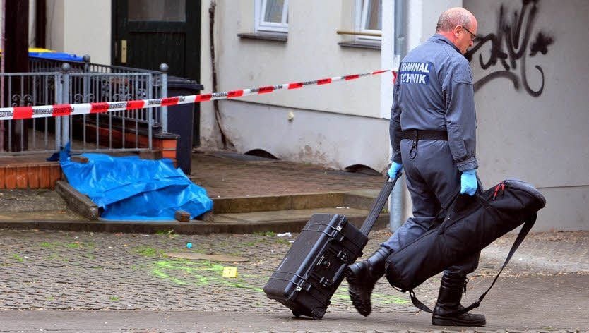 Ein Kriminaltechniker ist auf dem Weg zur Sicherung von Spuren, die vor dem und im Haus gefunden wurden.
