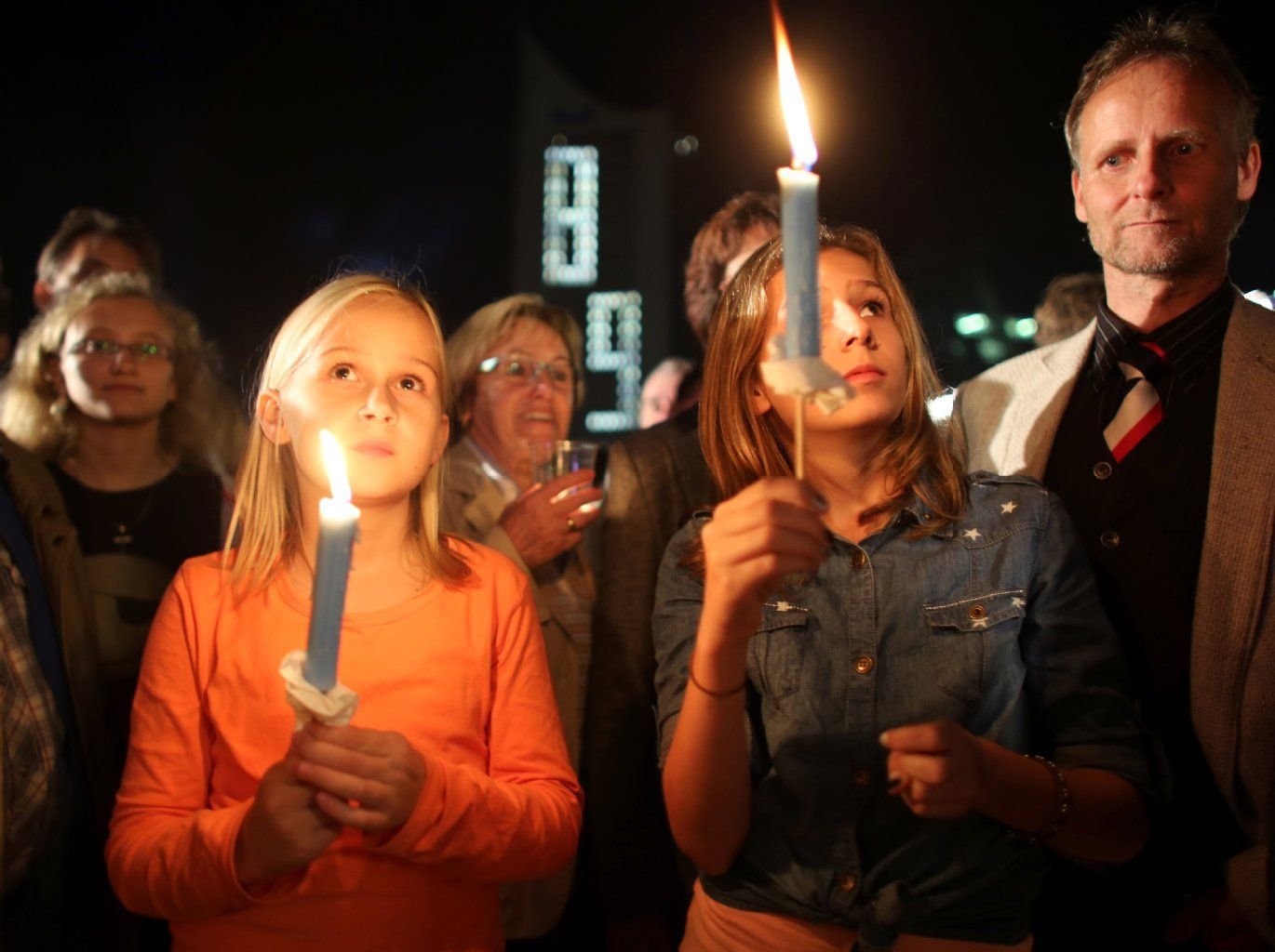 Besucher des Lichterfest stehen mit Kerzen auf dem Augustusplatz.