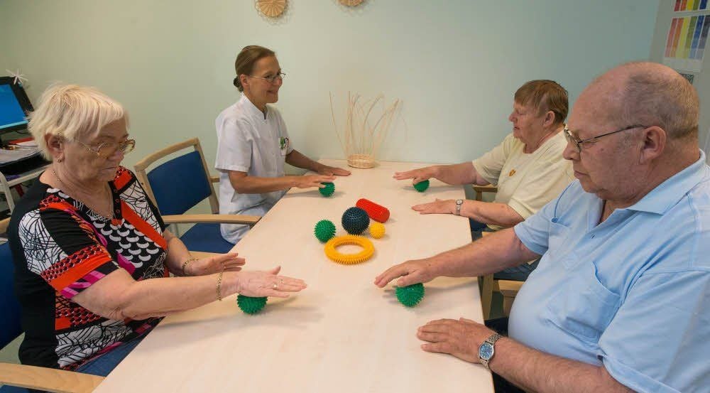 Ergotherapeutin Birgit Otto (2.v.l.) während einer Übungsstunde mit drei Patienten.