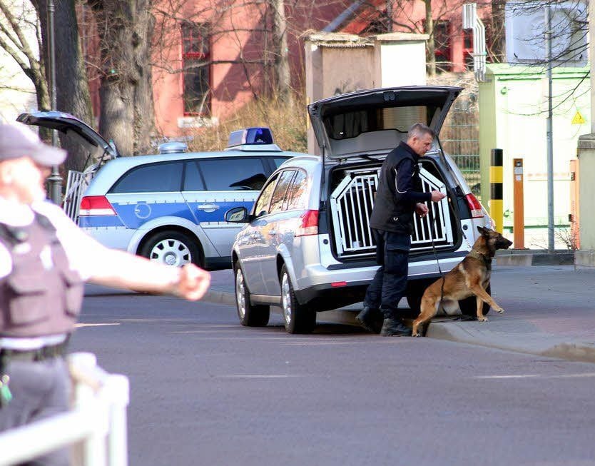 Ein Beamter macht sich mit einem Sprengstoffspürhund auf den Weg.