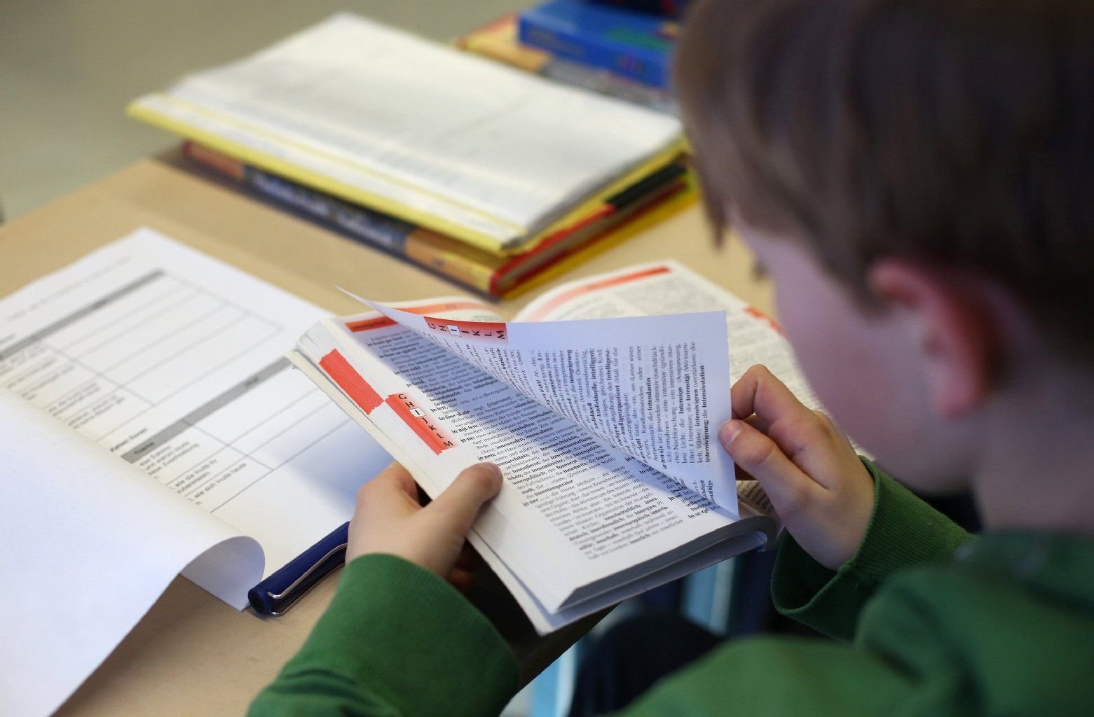 Ein Junge blättert in einem Schulbuch