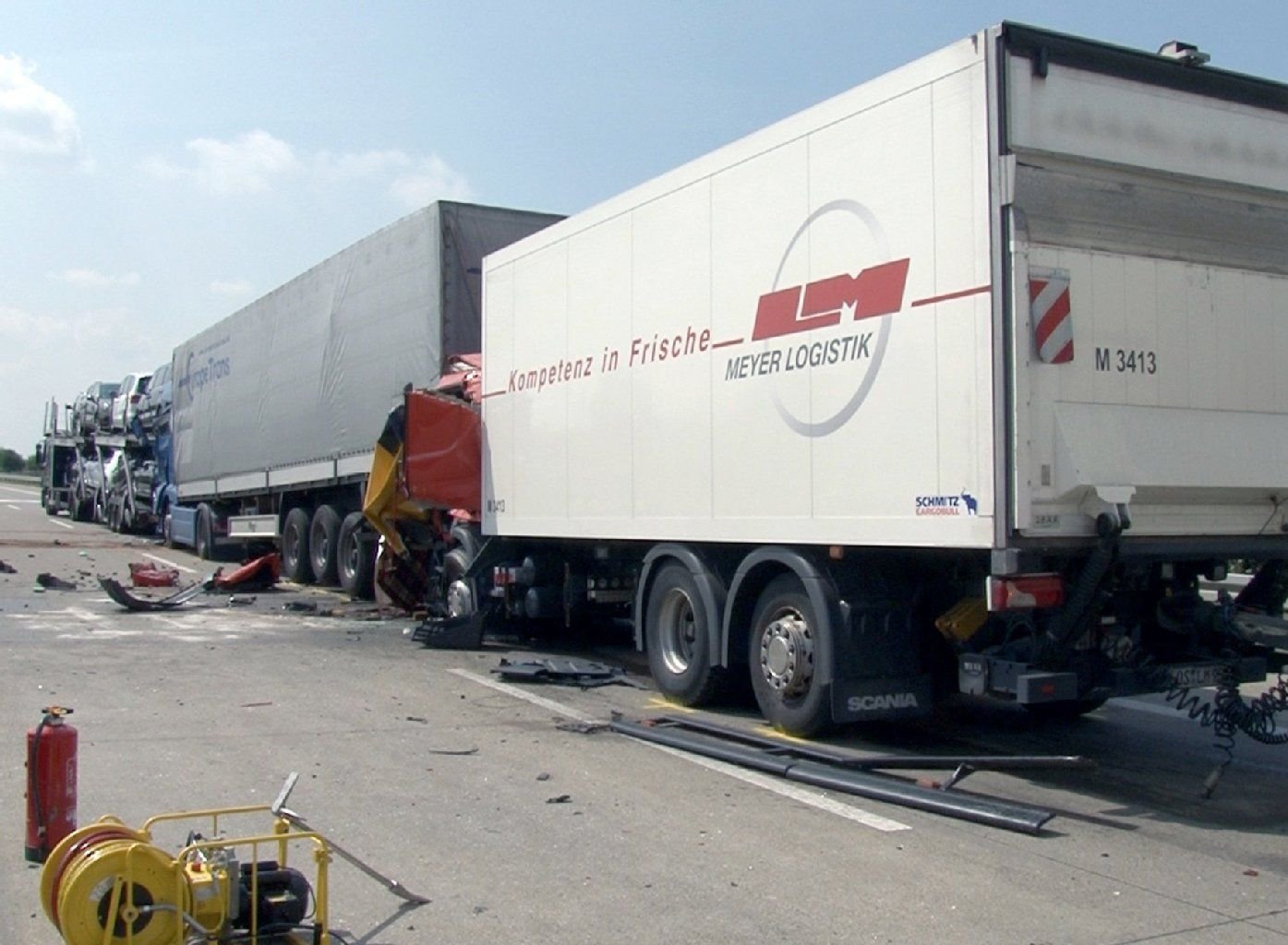 Ein zerstörtes Fahrzeug steckt am 08.08.2014 auf der Autobahn 14 bei Schönebeck (Sachsen-Anhalt) zwischen zwei Lastwagen fest.