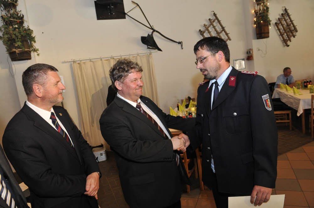 Landrat Uwe Schulze und Dietmar Krause zeichnen Sven Warmuth, Chef der Libbesdorfer Feuerwehr, mit der Fluthelfer-Nadel aus.