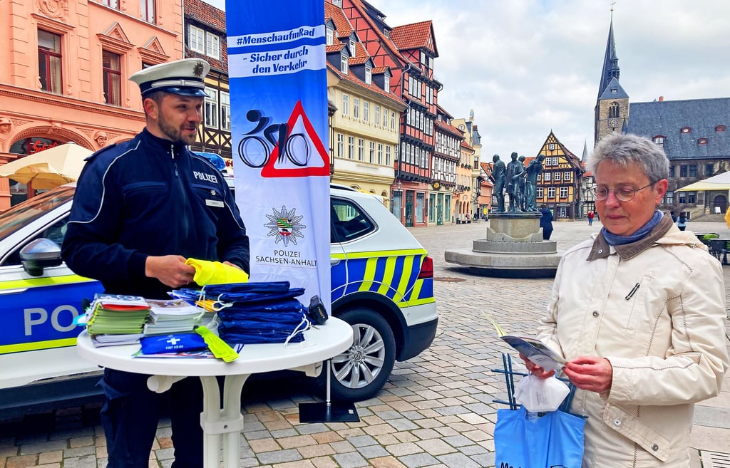 Bärbel Arndt lässt sich am Infostand der Polizei in Quedlinburg von Polizeikommissar Sebastian Fabich zur Sicherheit auf dem Rad beraten.