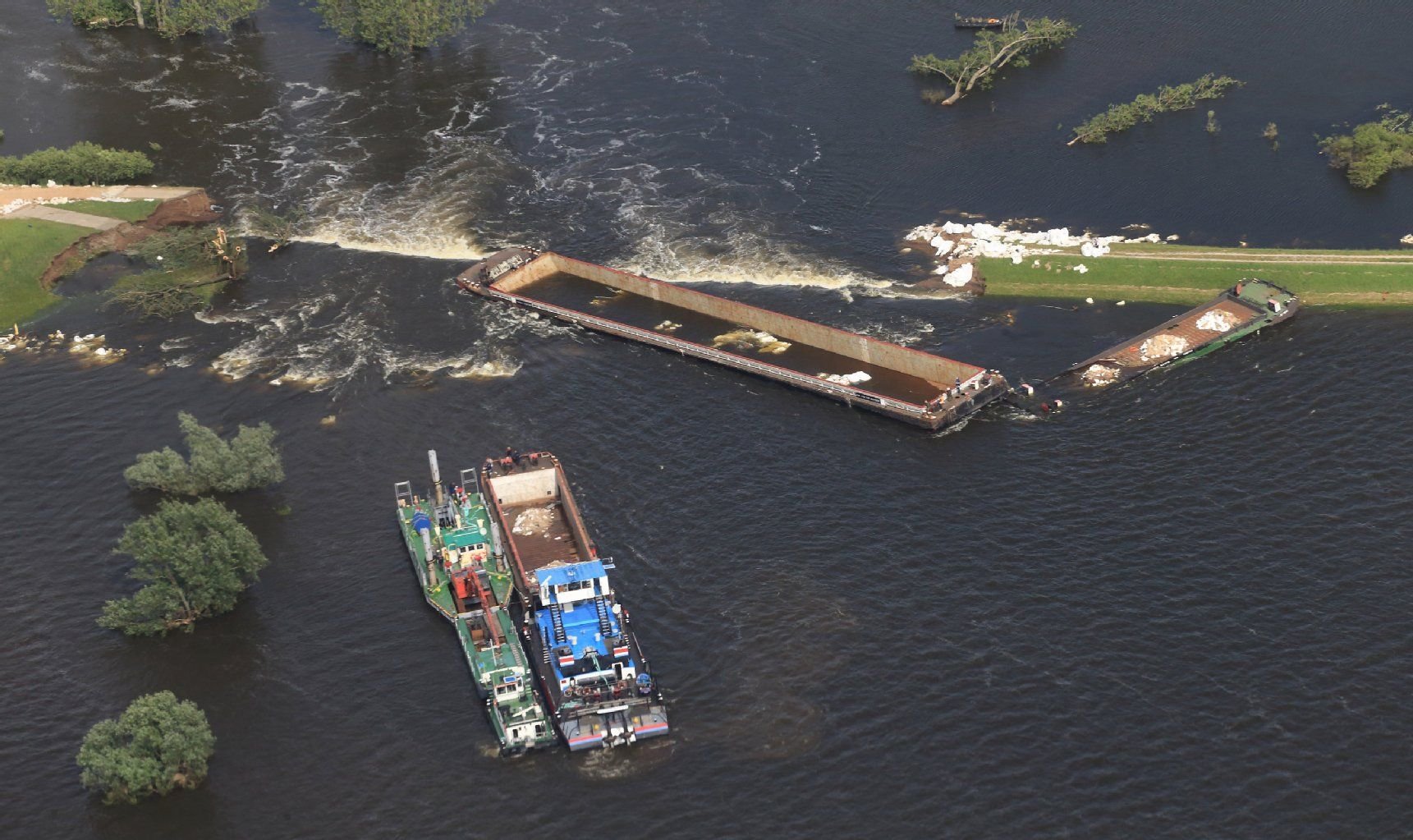 Der dritte Lastkahn wird zum gebrochenen Elbdeich bei Fischbeck gebracht. Der Kahn wird von einem Schubschiff vor den etwa 20 Meter breiten noch verbliebenen Durchfluss am Elbedeich geschoben und versenkt werden.