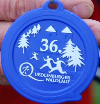 Eine solche blau-weiße Medaille wird im Ziel für jedes Kind bereitgehalten.