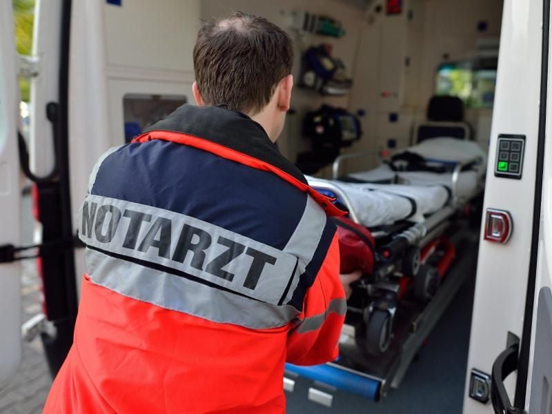 Ein Notarzt an einem Rettungswagen.