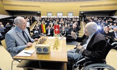Die Schachlegenden Viktor Kortschnoi (rechts) und Wolfgang Uhlmann sitzen sich am Schachbrett gegenüber.