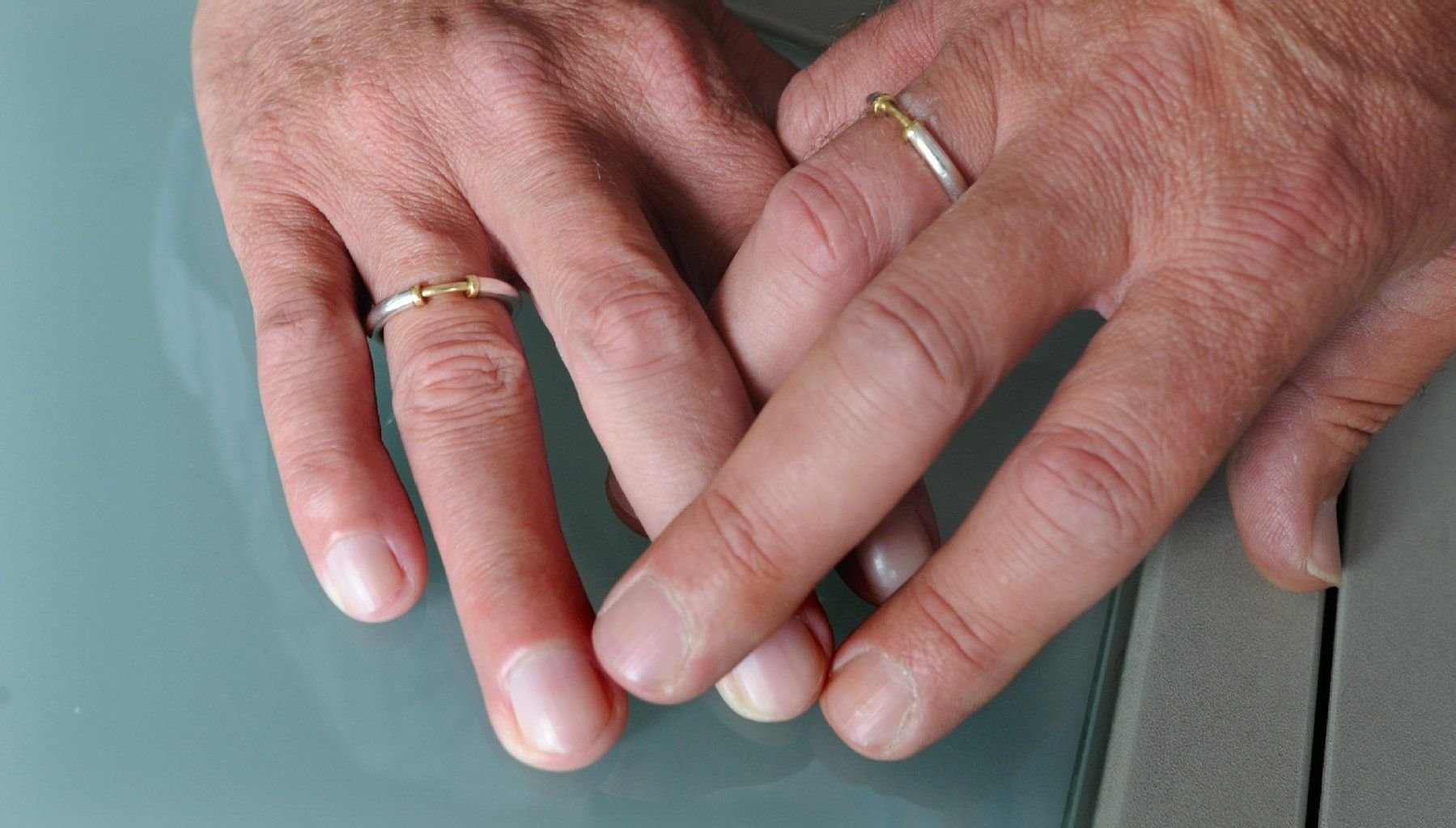 Ein homosexuelles Paar zeigt seine Ringe.