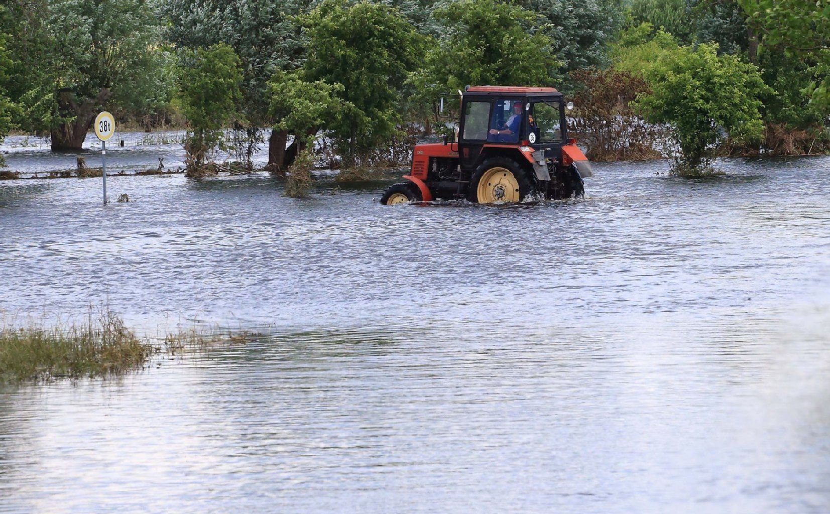 Ein Traktor fährt durch die abnehmende Flut der Elbe in Fischbeck.