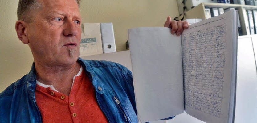 Axel Pich überreicht eine Unterschriftensammlung.