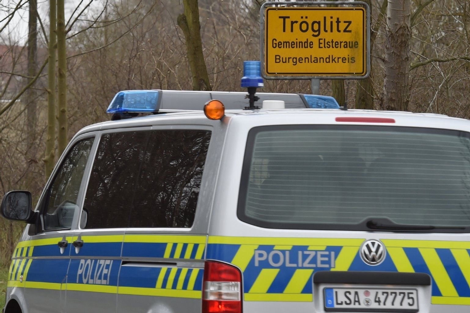 Ein Polizeifahrzeug fährt in die Gemeinde Tröglitz in Sachsen-Anhalt ein.
