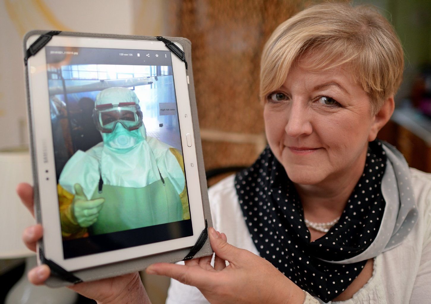 Hebamme Annett Böhme hält in Leipzig ein Foto in der Hand, das sie Ende Oktober während eines Vorbereitungskurses für Delegierte in das Ebola-Gebiet zeigt.