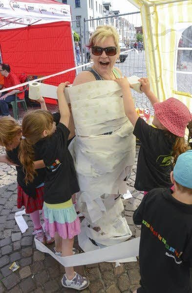 Einige Disziplinen beim Kindersportfest: Kinder der Kita „Pinocchio“ wickeln Erzieherin Sandy Kujau beim Mumienspiel mit Toilettenpapier ein.