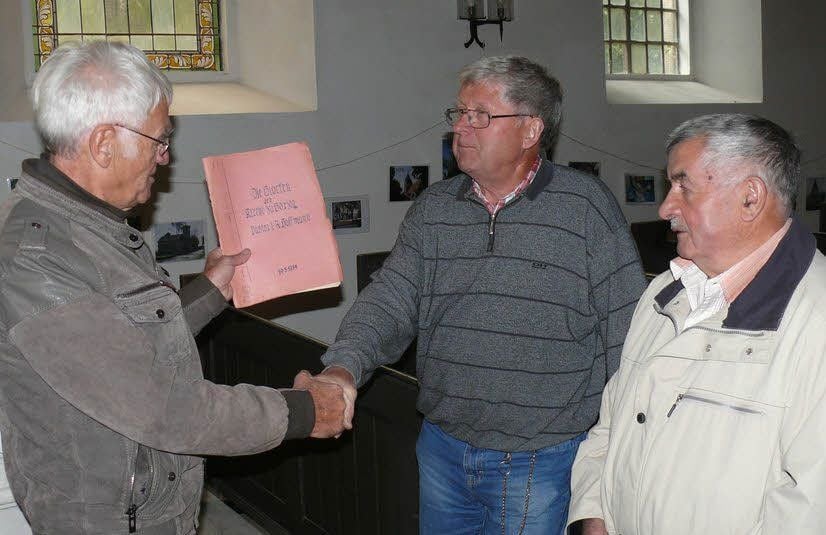 Der Organisator des Treffens, Wolfgang Schulz (l.), übergibt die Glocken-Chronik an Alfred Hohmann (M.) und Joachim Viehl.