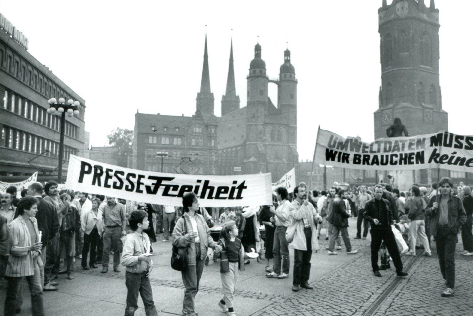 Während einer Montagsdemo im Oktober 1989 fordern Bürger auf dem halleschen Markt mit dem „Freiheit“-Logo auf dem Transparent mehr Pressefreiheit.