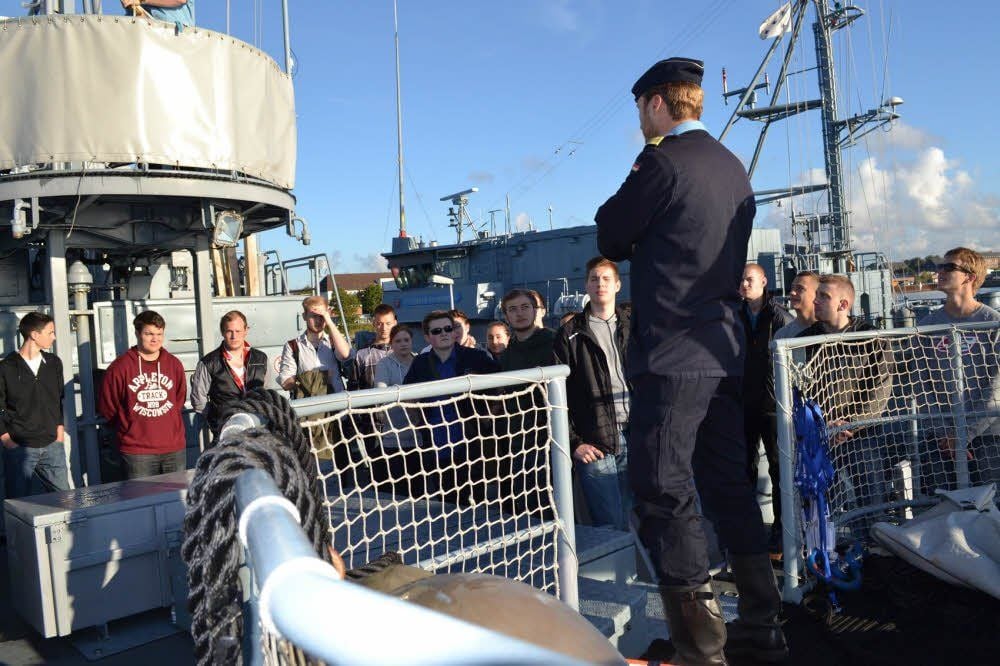 Der Kommandant erklärt jungen Leuten , was sie auf dem Minenjagdboot erwartet.