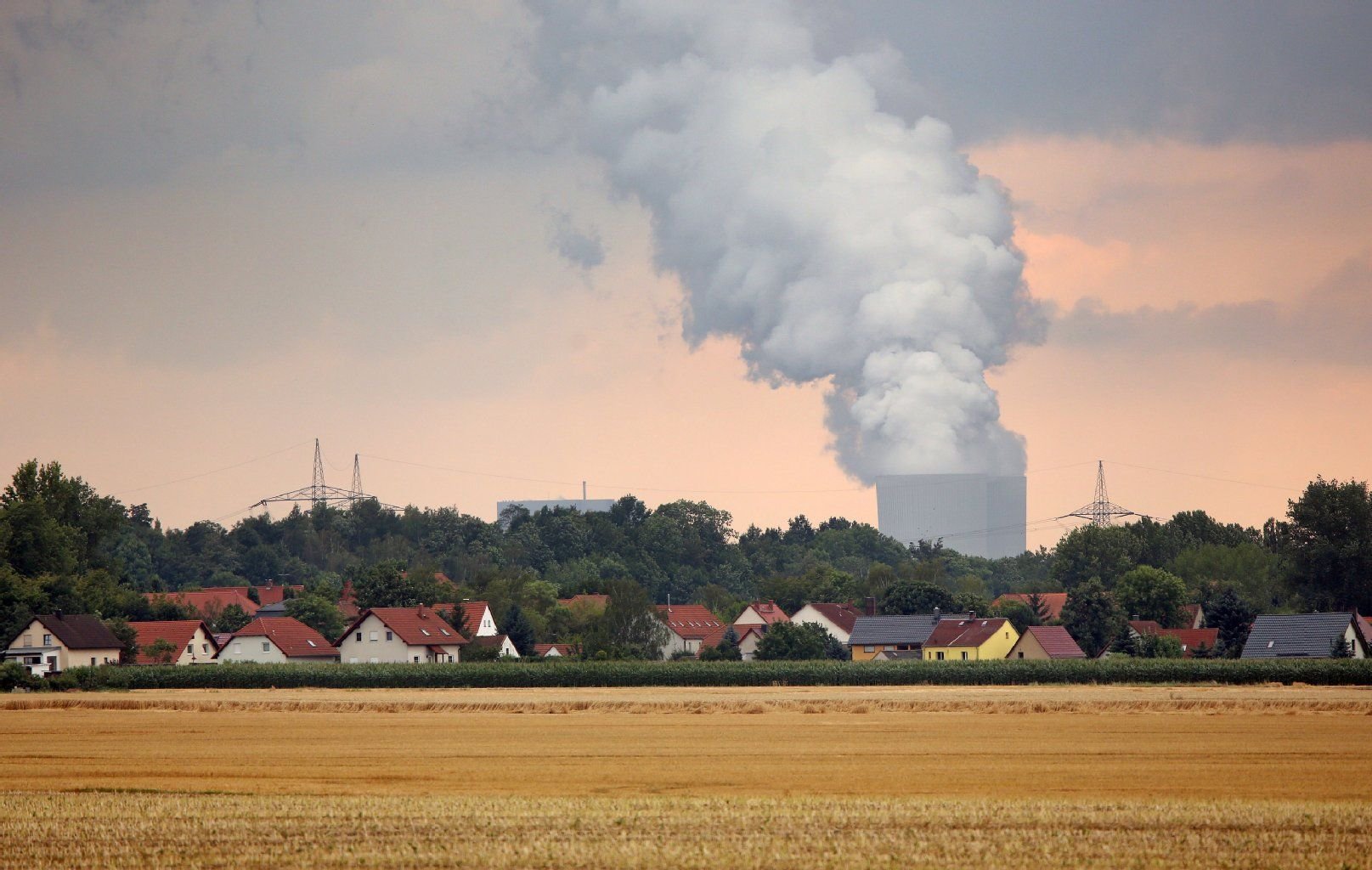 Die Kühltürme des Braunkohlekraftwerks Lippendorf dampfen hinter dem Dorf Mölbis (Sachsen).