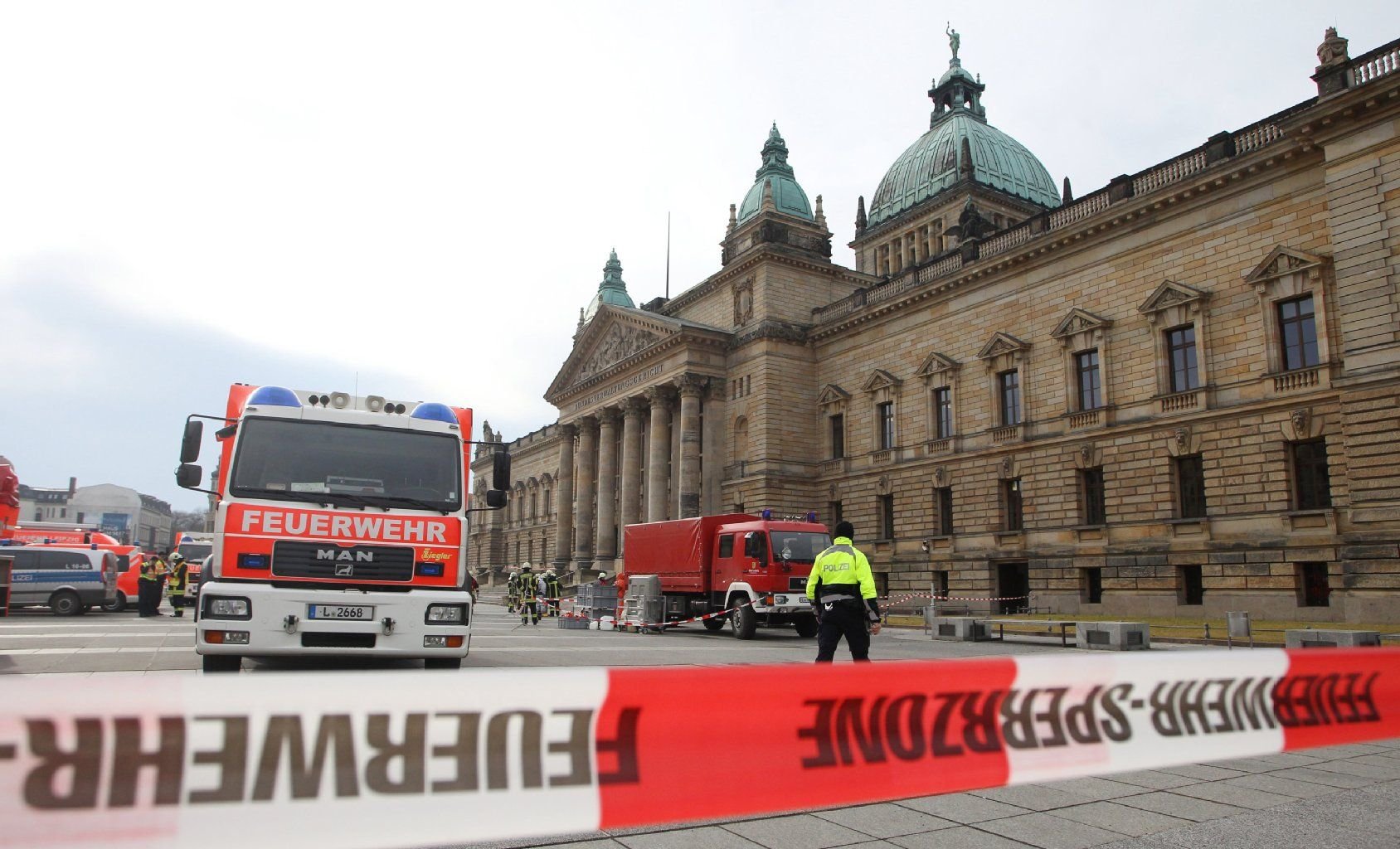 Einsatzkräfte der Feuerwehr stehen im Februar 2014 in Leipzig vor dem Bundesverwaltungsgericht.