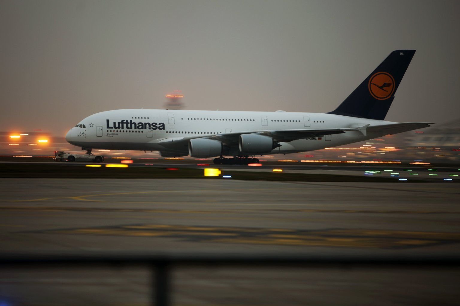 Ein Flugzeug der Lufthansa (Airbus A380) wird über das Rollfeld gezogen.