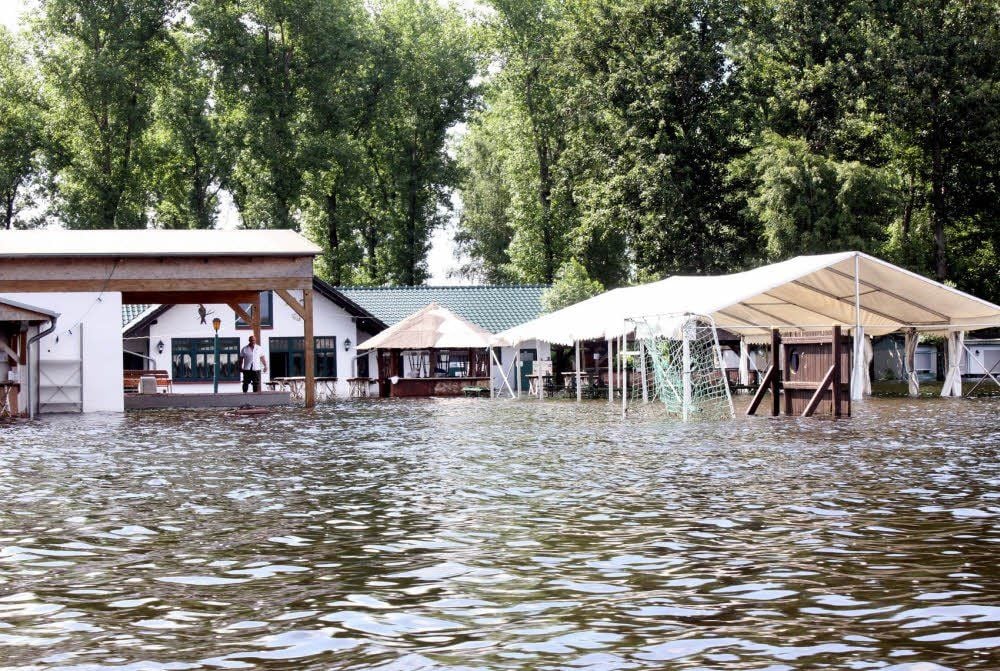 Akazienteich und Campingplatz sind komplett überflutet: Blick vom Strand zur Gaststätte und zur Bühne.