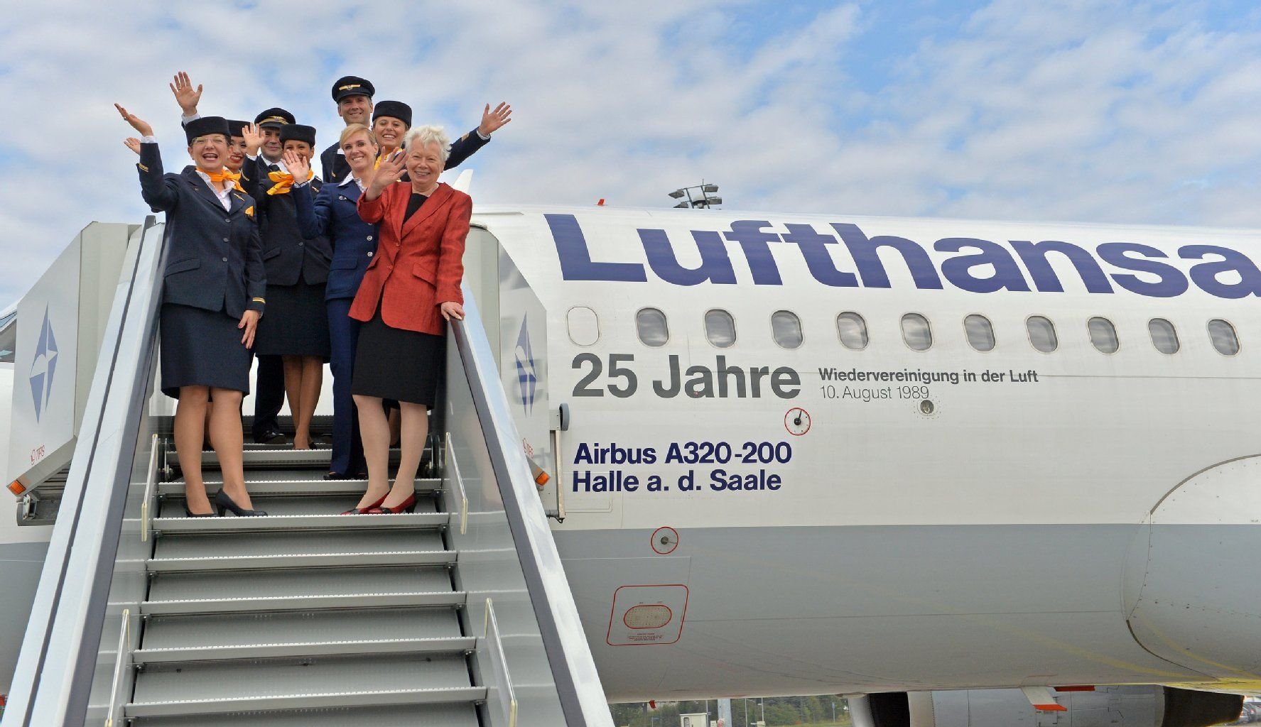 Die Crew des Lufthansa-Airbus A320 "Halle a.d. Saale" steht am 10.08.2014 auf dem Flughafen Leipzig/Halle in Schkeuditz (Sachsen) gemeinsam mit der ehemaligen Flugbegleiterin Barbara Boday (r) auf der Gangway.
