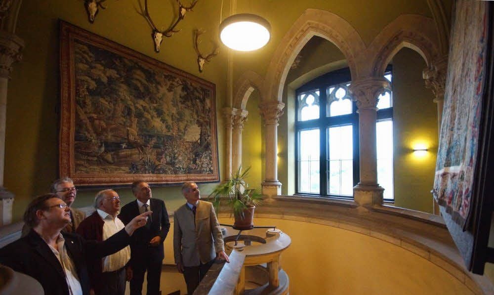Geschäftsführer Christian Juranek (l.) erklärt einen Gobelin im Treppenaufgang des teilsanierten Fahnenturms von Schloss Wernigerode.
