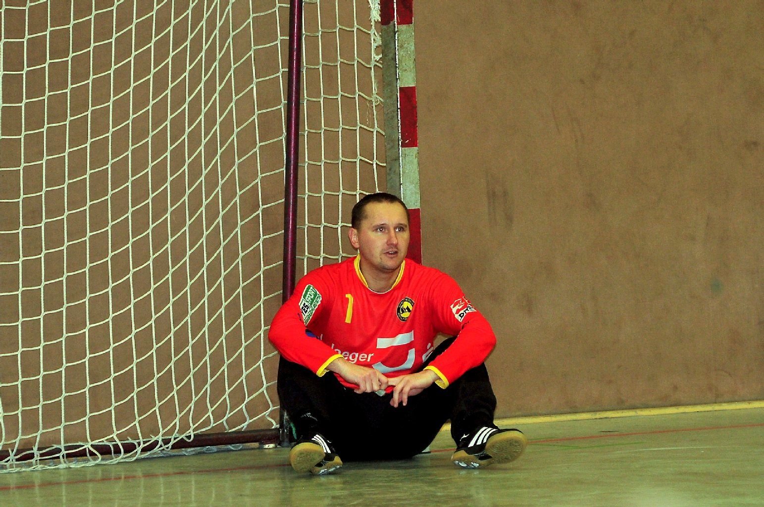 Anhalt-Torwart Artur Gawlik sitzt nach der Niederlage auf dem Hallenboden.