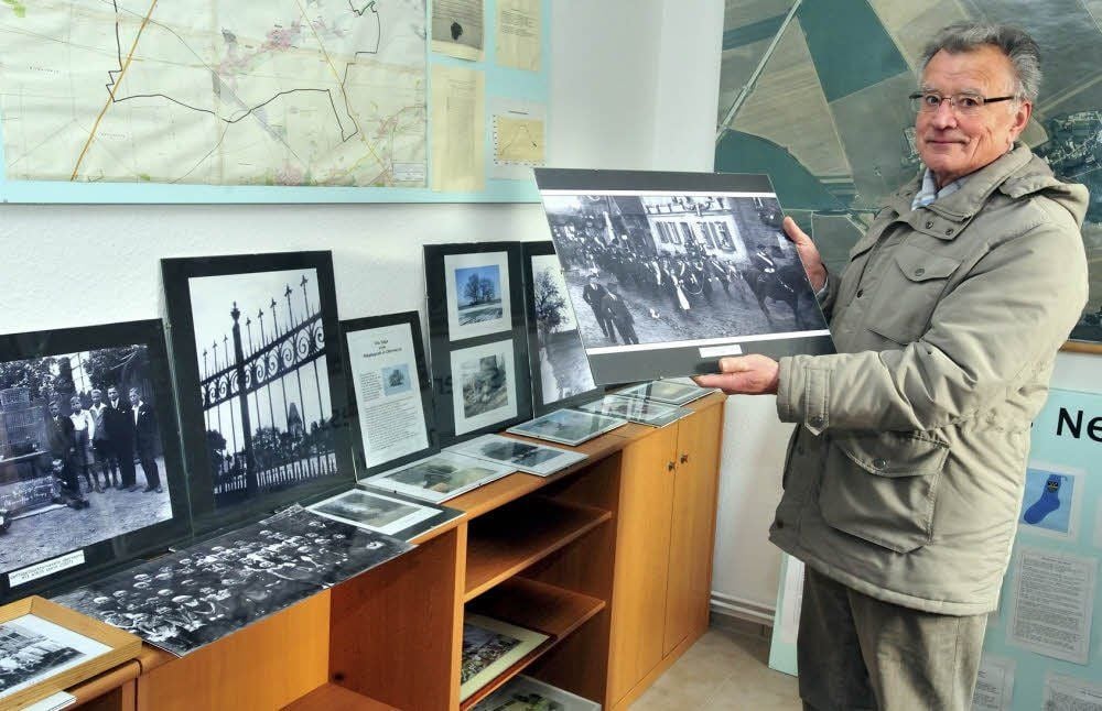 Helmut Dolde steht in den vom Heimatverein genutzten Räumen inmitten historischer Bilder.
