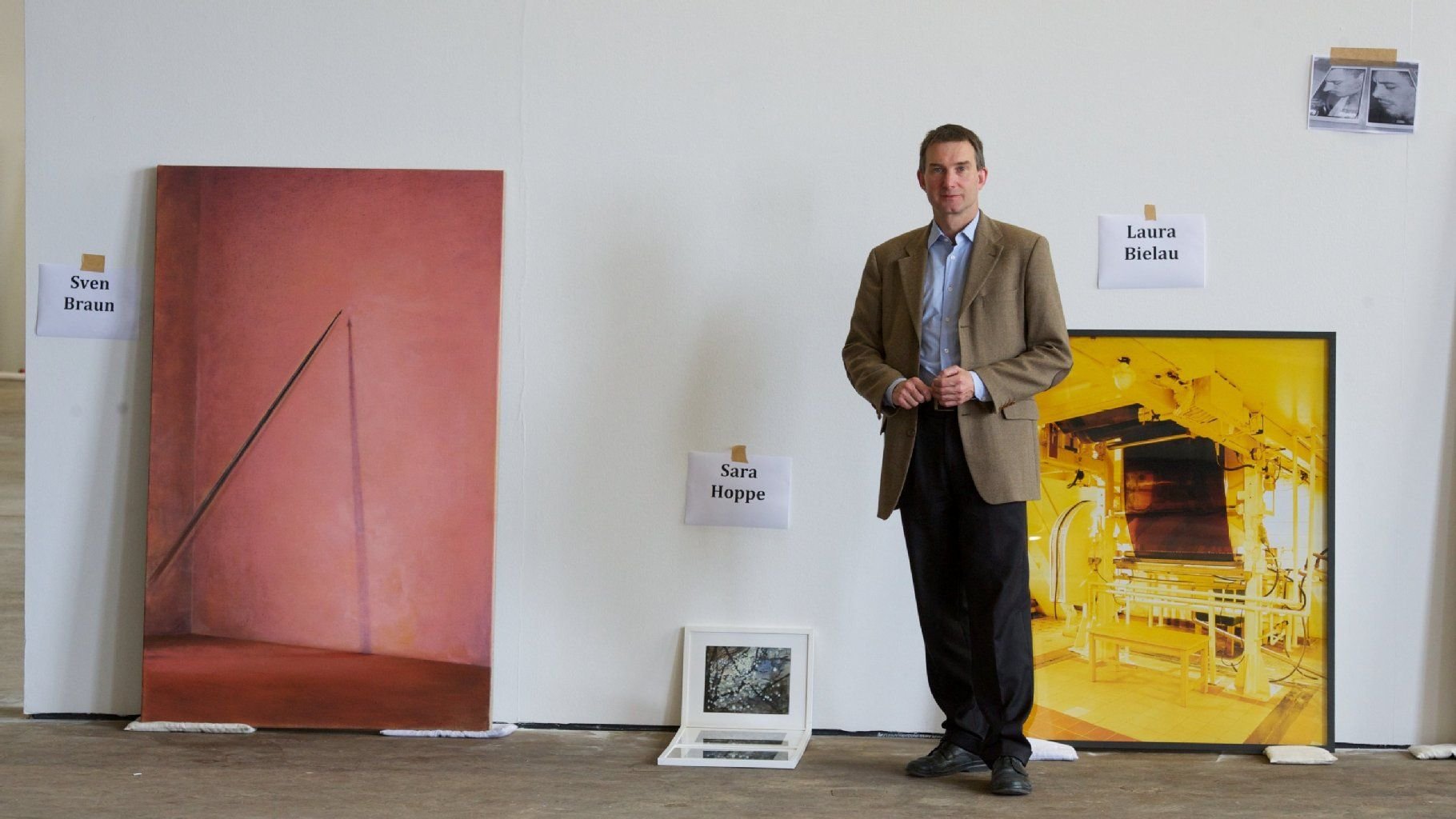 Vor Arbeiten der Künstler (l-r) Sven Braun (Angel, 2012), Sara Hoppe (Serie Points, 2011) und Laura Bielau (Maschine, 2008) steht der Direktor der Kulturstiftung Sachsen, Ralph Lindner, am 06.06.2012 in der Baumwollspinnerei in Leipzig. Auch in sparsamen Zeiten kauft Sachsen-Anhalt Bilder, Skulpturen und Fotografien.