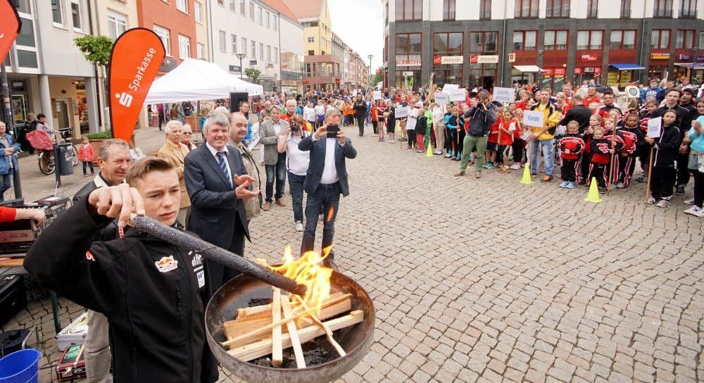 Der Harzgeröder Skispringer Paul Kinder durfte als Fackelläufer das olympische Feuer auf dem Fischmarkt entzünden.
