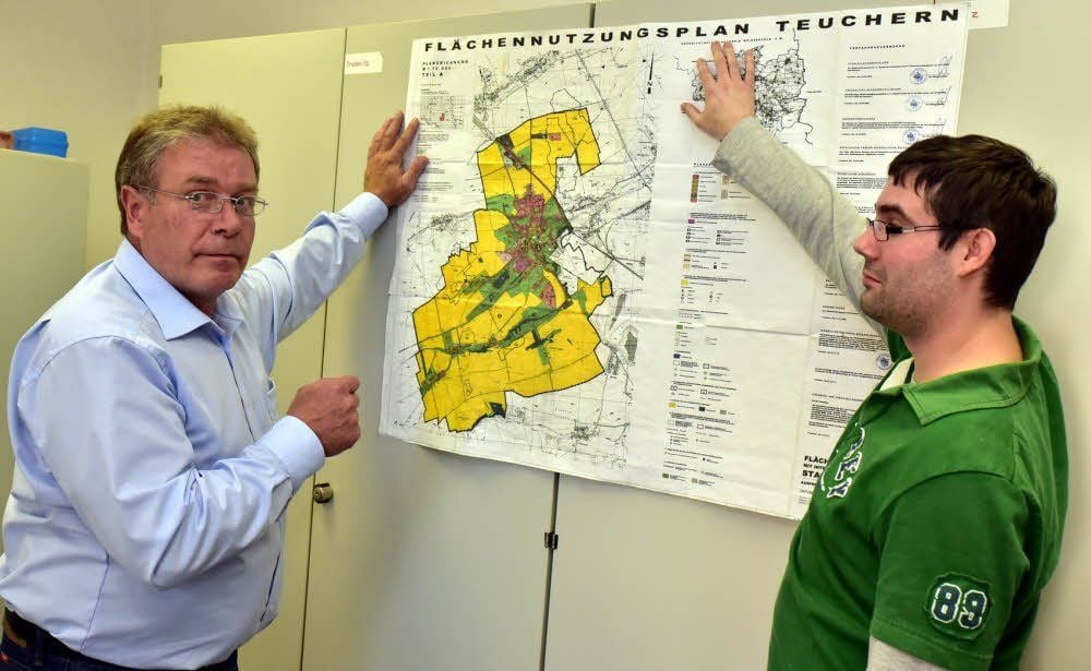 Bauamtsleiter Michael Frey und Lars Weidner, der das Bauamt vorübergehend leitete, begutachten den aktuellen Flächennutzungsplan der Stadt Teuchern mit seinen ausgewiesenen Wohn- und Gewerbeflächen.