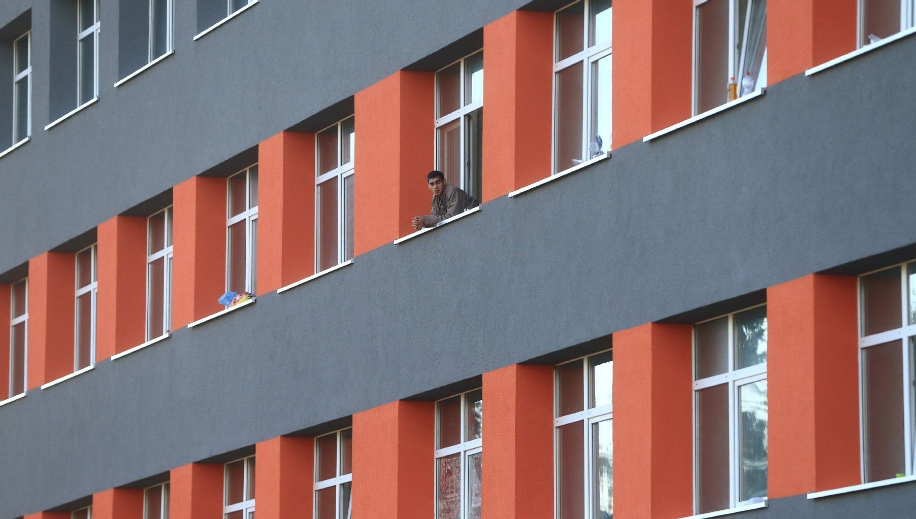 Ein Flüchtling blickt aus einem Fenster der Zentralen Aufnahmestelle für Asylbewerber (ZAST) in Halberstadt (Landkreis Harz).