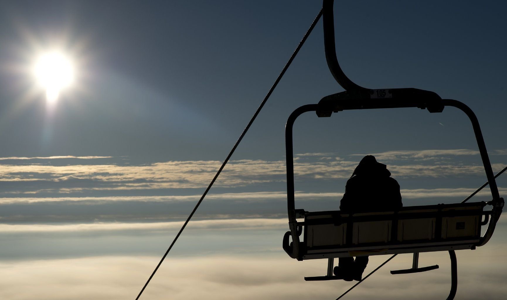 Ein Wintersportler sitzt auf dem Wurmberg bei Braunlage im Harz in einer Gondel des Hexenritt-Sessellifts.