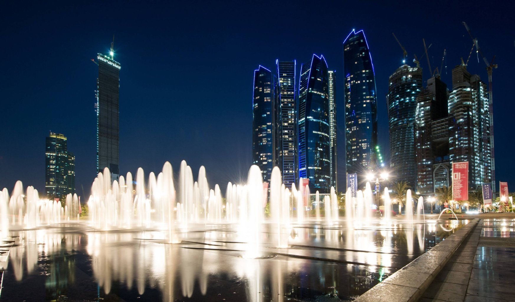 Die Etihad Tower in Abu Dhabi bei Nacht.