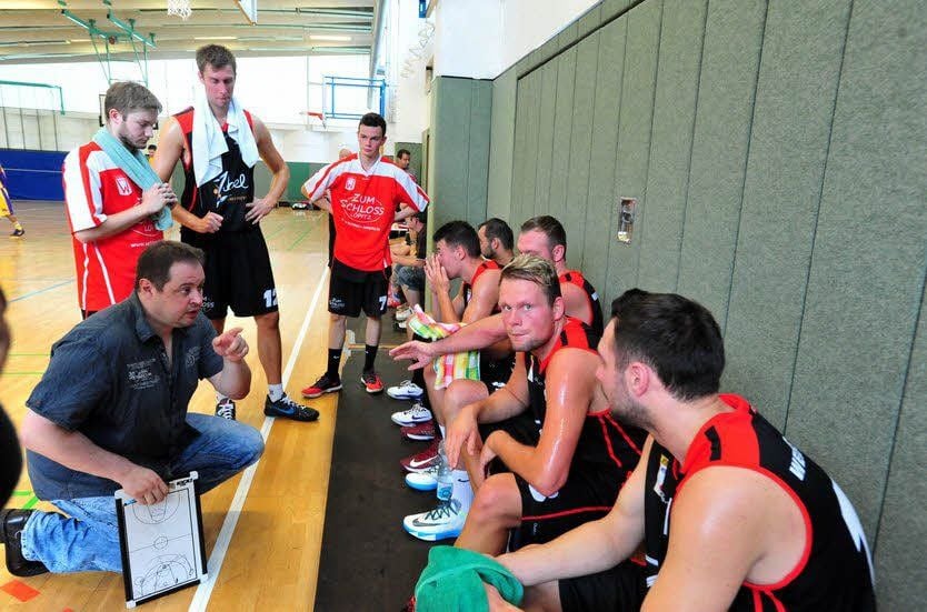 Der neue und alte Trainer Sören Fauß (kniend) spricht auf sein Team ein.