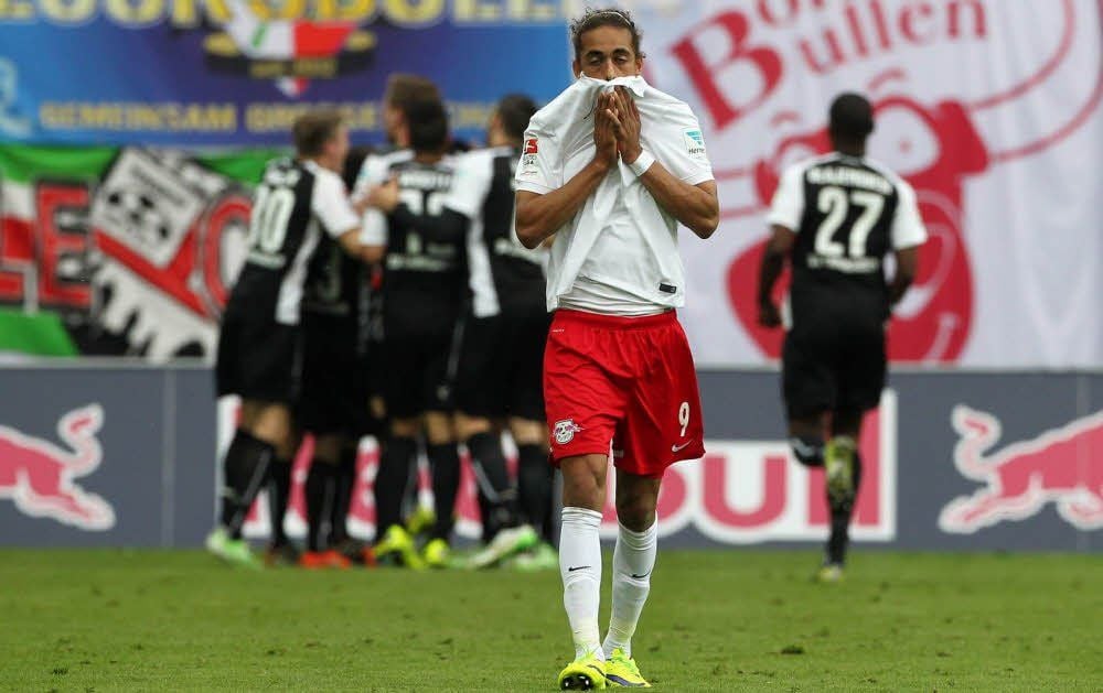 RB-Stürmer Yussuf Poulsen ist fassungslos, während die Spieler aus Sandhausen feiern.