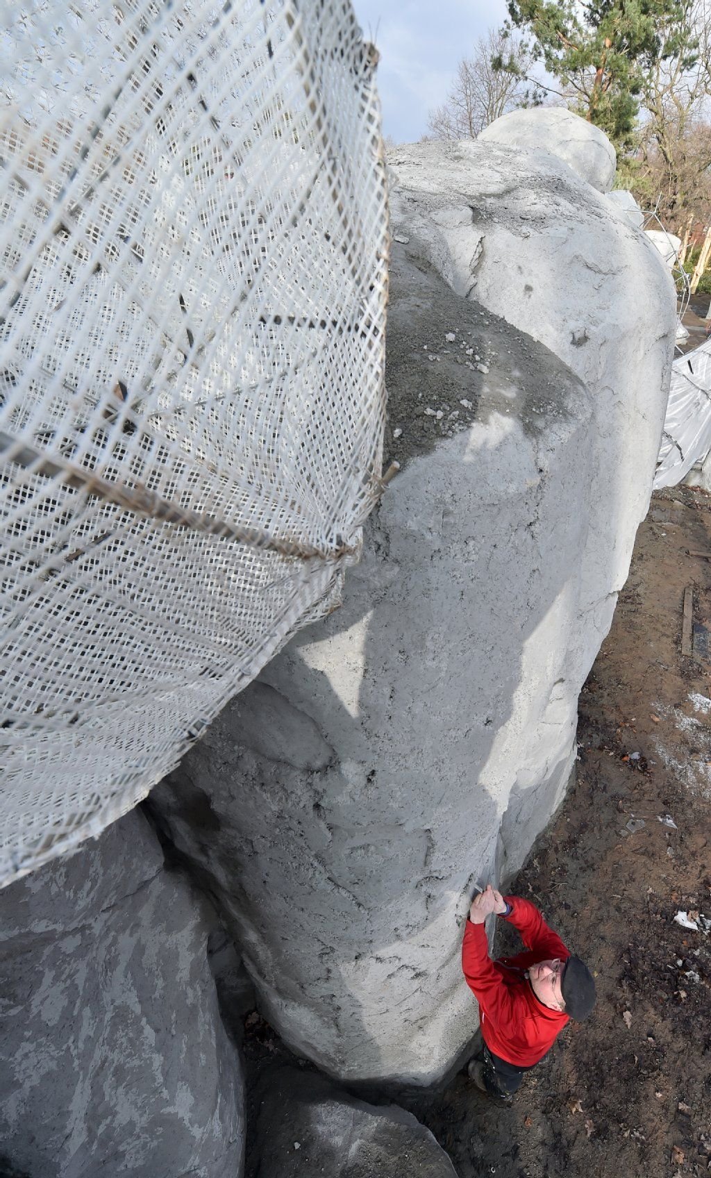 An einem Kunstfelsen in der zukünftigen Kopje-Landschaft des Zoos in Leipzig tragen Arbeiter Spritzbeton auf.