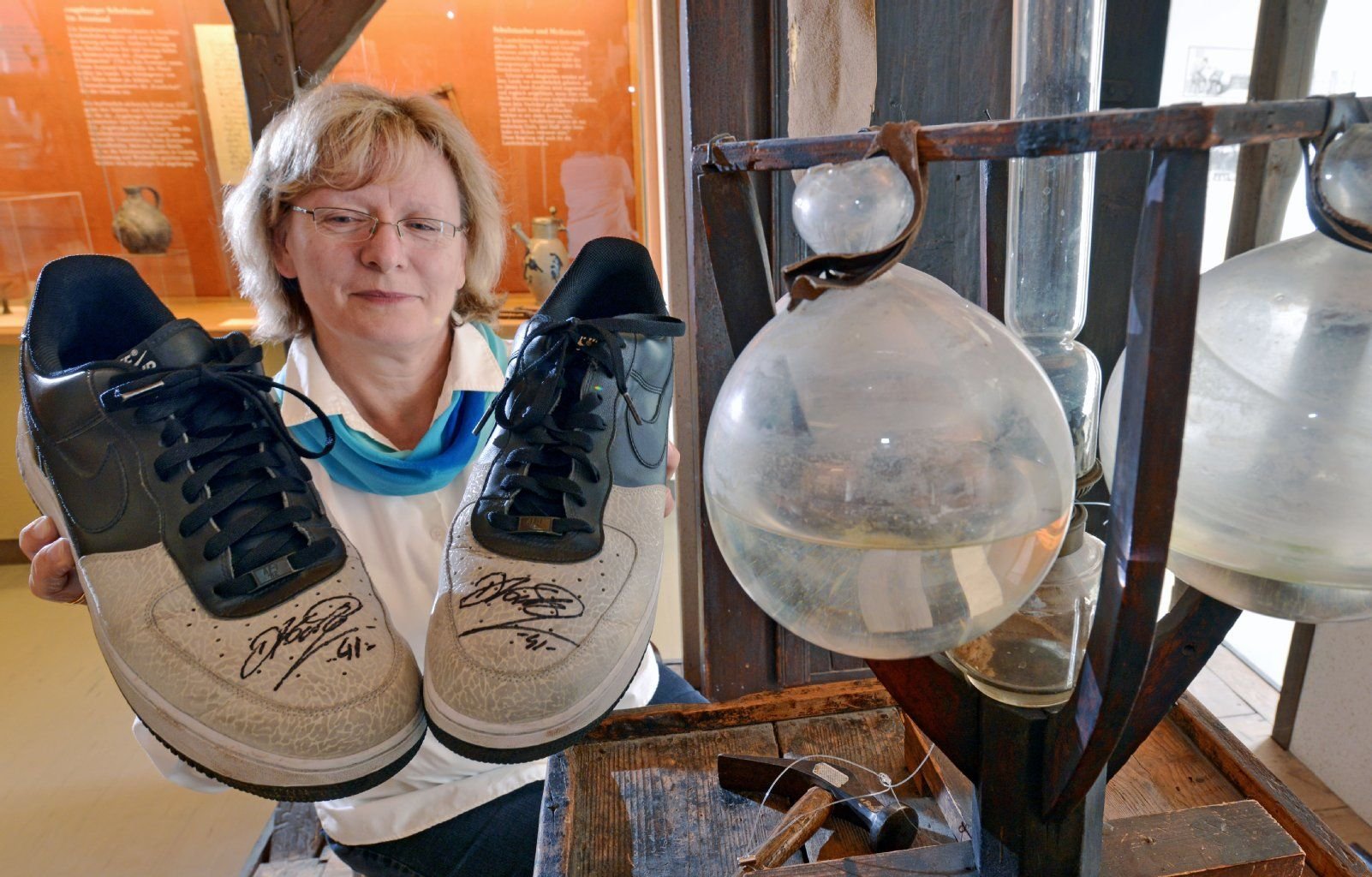 Ein Paar Schuhe des Basketballstars Dirk Nowitzki der Größe 51 präsentiert Kuratorin Angela Sengewald vom Schuhmuseum in Weißenfels.