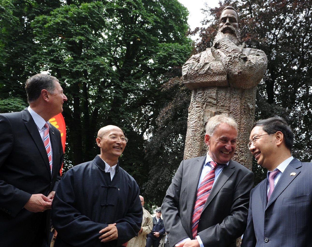 Der Wuppertaler Oberbürgermeister Peter Jung (CDU, l-r), der Künstler Zeng Chenggang, der Leiter des Engelshauses, Eberhard Illner, und Shi Mingde, Botschafter der Volksrepublik China in Berlin, posieren nach der Enthüllung des von der Volksrepublik China gestifteten Denkmals des Philosophen und Gesellschaftstheoretikers Friedrich Engels (1820-1895) in Wuppertal.
