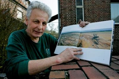 Wolfgang Hochstetter hält in Bitterfeld-Wolfen eine Abbildung des ehemaligen Tagebau Goitzsche in seinen Händen. Der 68-Jährige hat 35 Jahre lang im Bergbau gearbeitet. (FOTO: DDP)