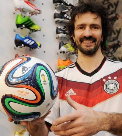 Lars Müller zeigt im DFB-Trikot den neuen Ball für die WM in Brasilien.