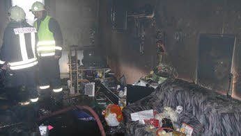 Nach dem Ende der Löscharbeiten suchen Feuerwehrleute in der Wohnung nach Glutnestern.