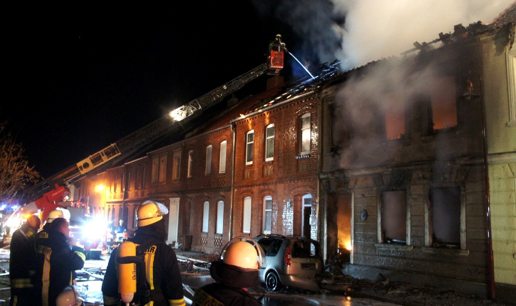 Feuerwehrleute löschen in Tangermünde (Sachsen-Anhalt) den Brand in einer Häuserzeile.