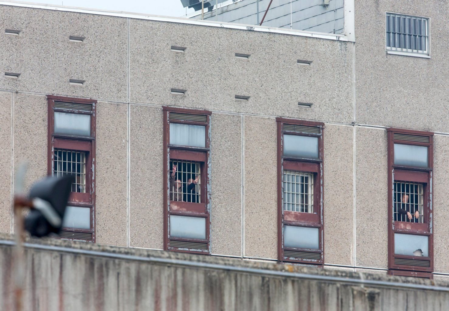 Gefangene blicken am Karfreitag in der Justizvollzugsanstalt in Goldlauter (Thüringen) aus den Fenstern. In dem Gefängnis hat ein Mann eine Geisel genommen.