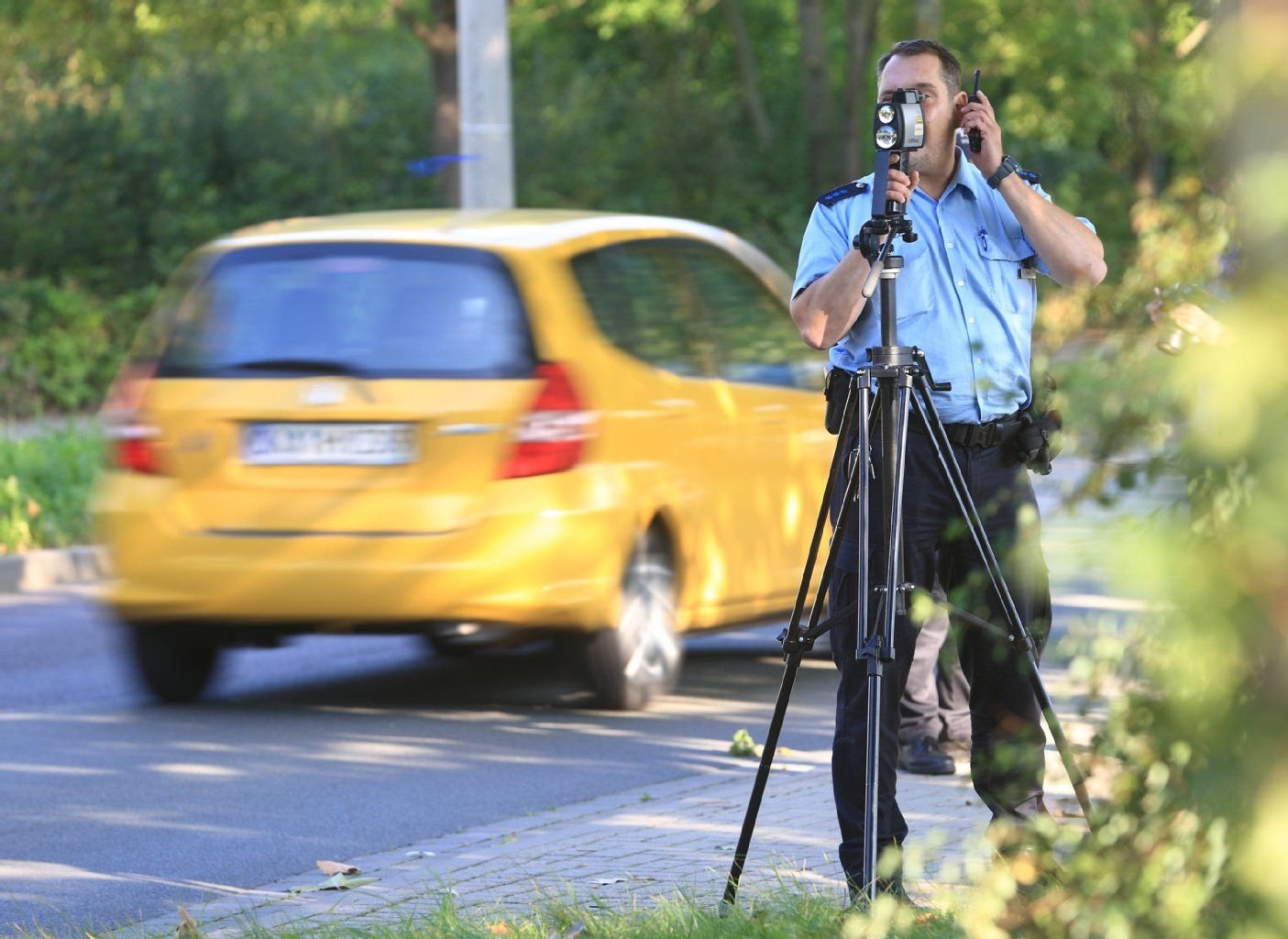 Ein Polizist überwacht am 18.09.2014 die Geschwindigkeit von Fahrzeugen in Magdeburg (Sachsen-Anhalt).
