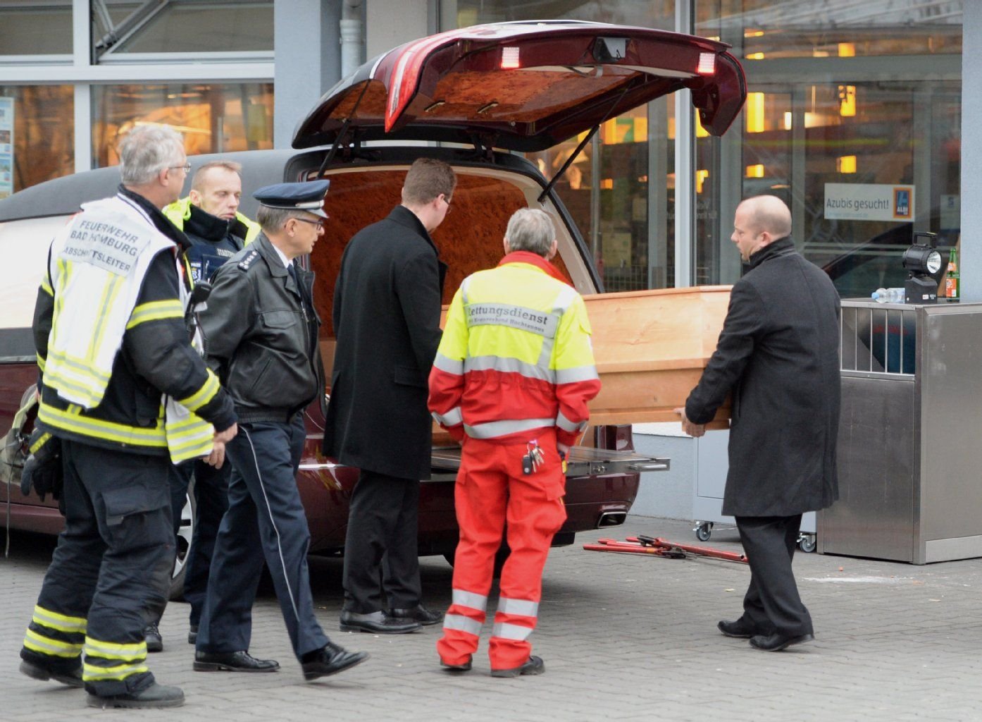 Bestatter tragen einen Sarg in das Innere des Aldi-Marktes in Bad Homburg.