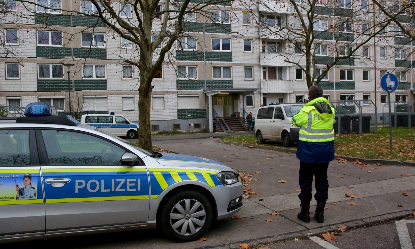 Ein Streifenwagen der Polizei steht nach dem Unglück vor dem Hochhaus in der Grenobler Straße in Halle.